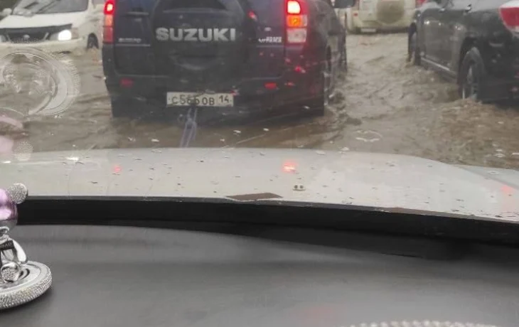 Во время ливня двое парней вытащили машину с ребенком из водяной ловушки